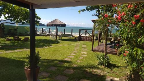 um jardim com vista para a praia e para o oceano em Light Beach Residence em Florianópolis