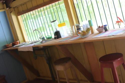 eine Küchentheke mit zwei Hockern und einem Fenster in der Unterkunft Casa en la selva con acceso al río - Casa Ikua in Iquitos
