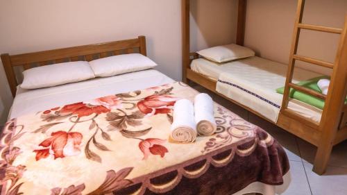 Un dormitorio con dos camas con toallas en la cama. en Pousada São Nicolau, en Cachoeira Paulista