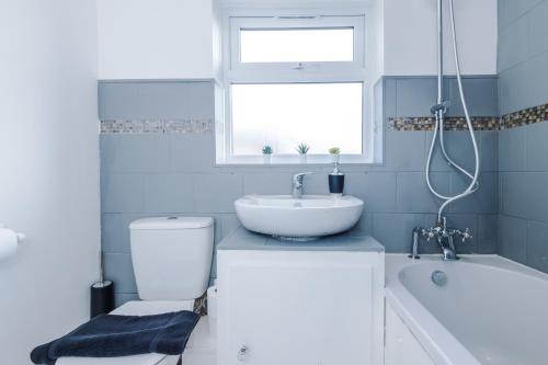 La salle de bains est pourvue d'un lavabo, de toilettes et d'une baignoire. dans l'établissement Stylish House in Stalybridge with WiFi & Parking Sleeps 8 by PureStay, à Stalybridge