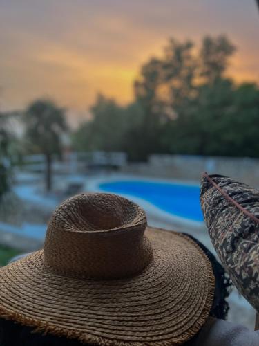 una persona che indossa un cappello di paglia davanti a una piscina di Apartments Villa Klaudia - Adults Only a Crikvenica