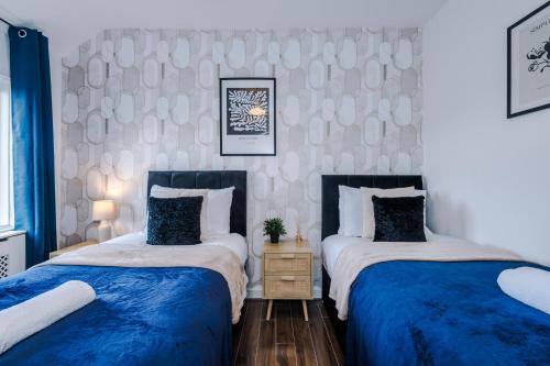 two beds sitting next to each other in a bedroom at Stylish House in Stalybridge with WiFi & Parking Sleeps 8 by PureStay in Stalybridge