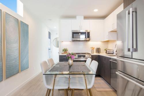 a kitchen with a glass table and white cabinets at 2BR 2BA Capitol Hill Cozy Haven- Rooftop in Seattle