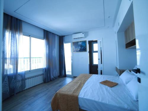 a bedroom with a large bed and a large window at La reine de Sidi Bou Said in Sidi Bou Saïd