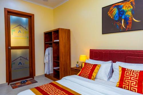 - une chambre avec un lit et une peinture d'éléphant sur le mur dans l'établissement F.A.M Homes, à Dar es Salaam