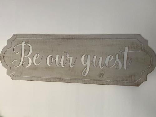 a sign that says be our guest on a wall at Cosy cottage in Chard