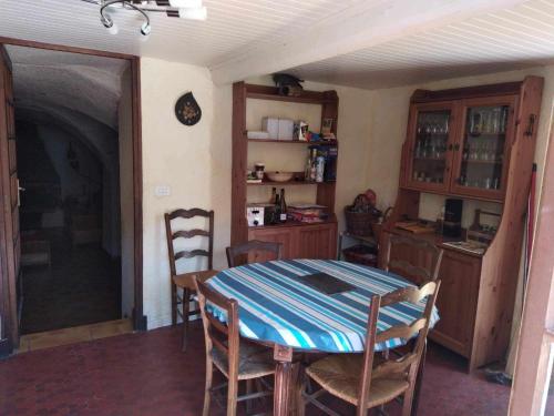 een keuken met een tafel en stoelen in een kamer bij La forestière 