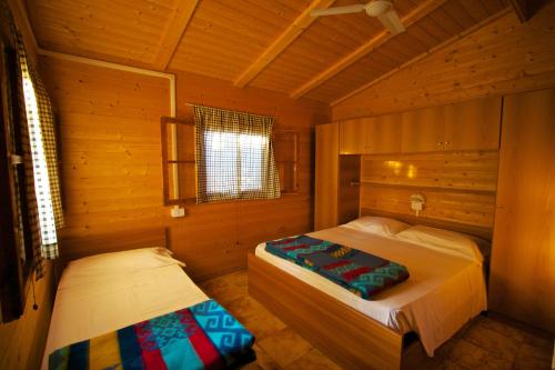 1 dormitorio con 2 camas en una cabaña de madera en Villaggio La Siesta, en Marina di Camerota