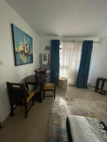 a living room with a table and chairs and a window at Langata, Deliverance Church, Jamhuri Heights Apartments in Nairobi