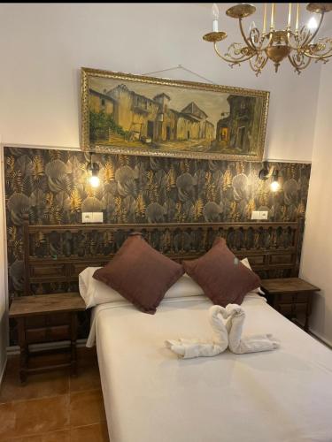 a bedroom with a bed with a painting on the wall at Los corzos in Burgohondo