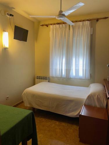 1 dormitorio con 2 camas y ventana en Hostal El Corzo, en Villafranca