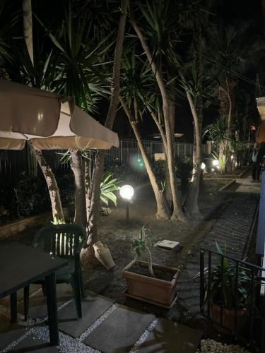 a park at night with a table and chairs and trees at L'abete in Villabate