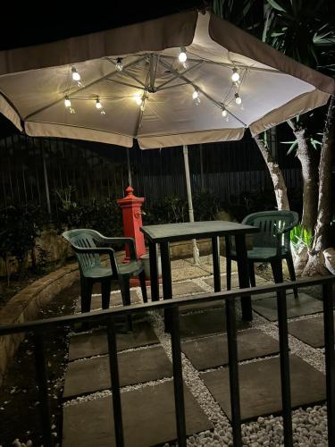 a table and two chairs under an umbrella at L'abete in Villabate