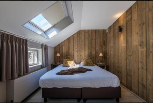 Schlafzimmer mit einem großen Bett und einem Dachfenster in der Unterkunft Jeanne in Nieuwpoort