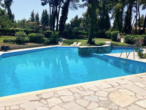 a large swimming pool with blue water at Luxurious Sani Villa Luna with shared pool in Sani Beach