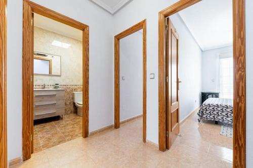 een slaapkamer met een bed en een badkamer met een spiegel bij Casa en Ciudad Quesada in Ciudad Quesada