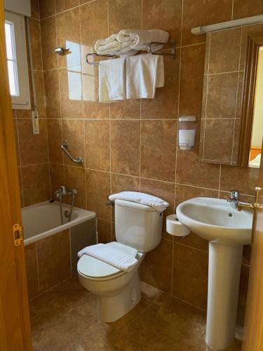 a bathroom with a toilet and a sink at Hostal El Corzo in Villafranca