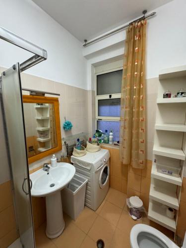 een badkamer met een wastafel en een wasmachine bij 3 Bedrooms Apartment in Shkodër