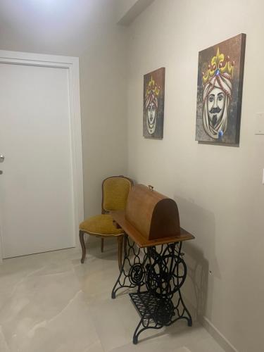 Marconi Rooms and Apartaments في Campobello di Licata: كرسي وطاولة في غرفة بها لوحات