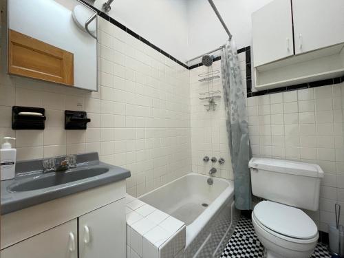 a bathroom with a sink and a toilet and a tub at Large Room in Charming Townhouse in New York