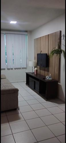 a living room with a tv and a couch at Apto para até 4 pessoas,com Wi-Fi,ótima localização, área de lazer com conveniência e piscina para criança in Petrolina