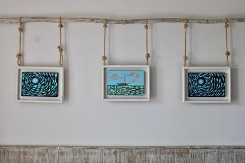 three framed photographs on a wall in a room at Naay Boutique Hotel Holbox in Holbox Island