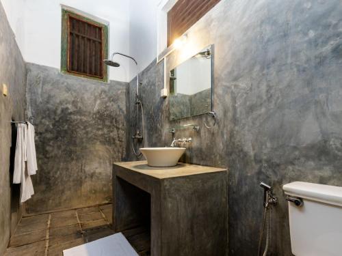 W łazience znajduje się umywalka i lustro. w obiekcie Joe's Bungalow Yala w mieście Kirinda