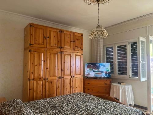 ein Schlafzimmer mit einem großen Holzschrank und einem TV in der Unterkunft Appartamento vista mare. in Campo Iemini