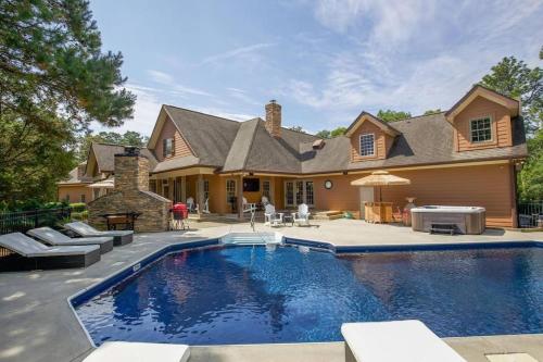una casa con piscina frente a una casa en Golf home Outdoor pool, Pool Table, Game room, Sleep up to 12, en Pinehurst