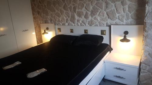a bedroom with a black bed with two lights on it at Tüyap Fair Elit Home in Istanbul