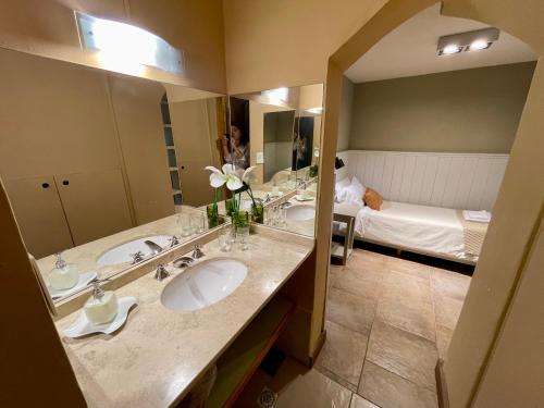 uma casa de banho com 2 lavatórios e um espelho grande em Las Marianas Hotel em San Carlos de Bariloche