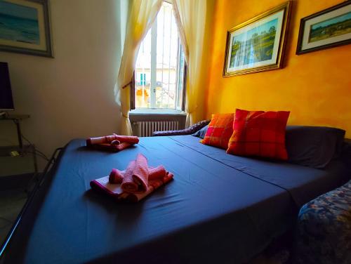 um quarto com uma cama com lençóis azuis e almofadas vermelhas em -La Terrazza nel Vigneto- [Golfo dei Poeti] em Tellaro