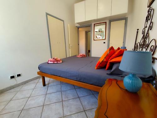 um quarto com uma cama grande com lençóis azuis e almofadas laranja em -La Terrazza nel Vigneto- [Golfo dei Poeti] em Tellaro