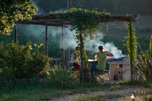 two people sitting at a table in a garden at Gîte La Grange Du Haut in Saint-Antoine