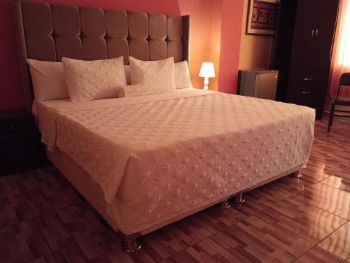 a large bed with a large headboard in a room at Madison Suite in Tacna