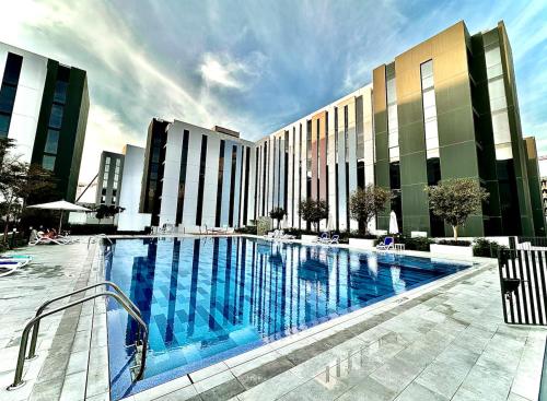 a large swimming pool in front of a building at Private Room in a Shared Apartment in Sharjah