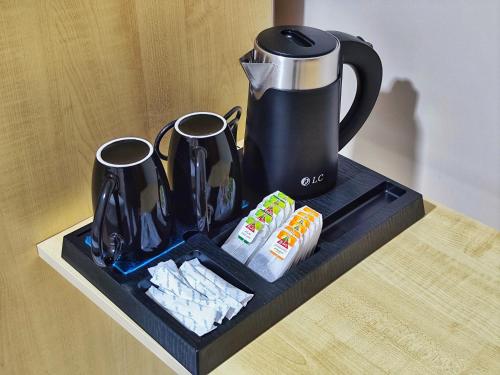 a black tray with a coffee pot and cups on a table at Rakan ApartHotel and Luxury Rooms in Wadi Musa