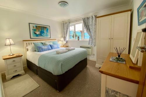 a bedroom with a bed and a desk and a window at Rushcroft Farm Cottages in Sway