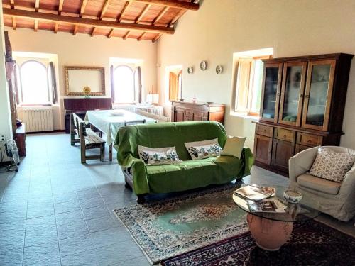 a living room with a green couch and a table at Poderino La Noce in Vinci