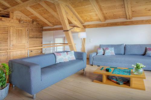 ein Wohnzimmer mit 2 blauen Sofas und einem Tisch in der Unterkunft Chalet Arsene et Lea - OVO Network in Manigod