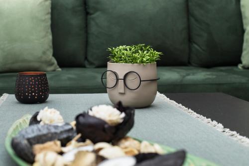 a table with a potted plant in a vase with glasses at Spiros Holidays House in Doukádes