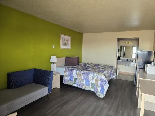 a hotel room with a bed and a couch at Lodge USA Motel in Guymon