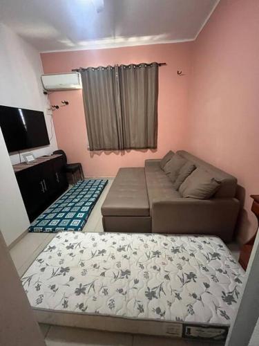 - un salon avec un canapé et un lit dans l'établissement Apto conjugado 1 quadra praia, à Rio de Janeiro