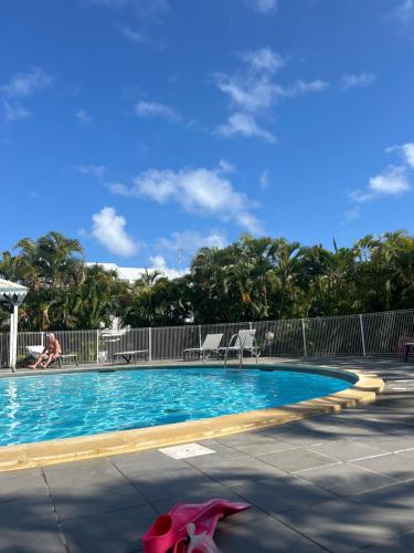 una piscina con 2 sillas y un animal rosa al lado en Azuri Lodge Duplex Marina, en Saint-François