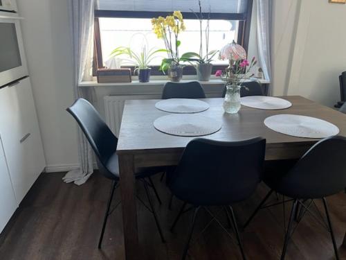 a dining room table with four chairs and a window at Nordic Company Lodge in Vuollerim