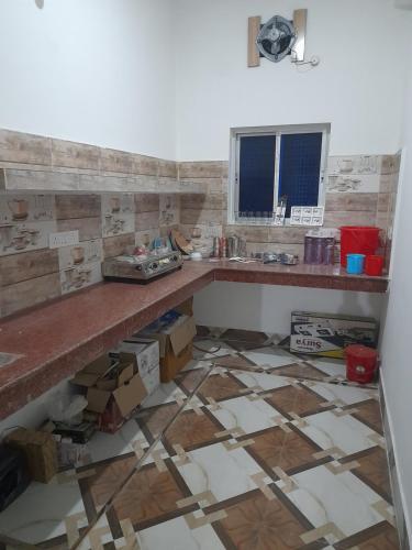 a kitchen with a counter and a tile floor at Gunjan Cottage in Deoghar