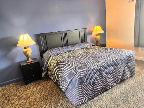 1 dormitorio con 1 cama y 2 mesitas de noche con lámparas en The Park at Foxborough en Branson