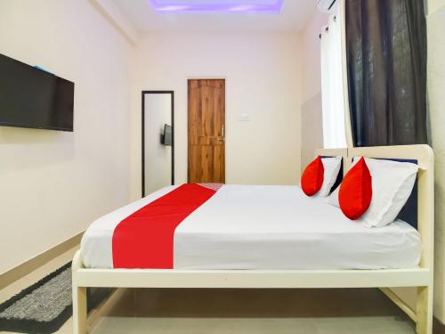 Schlafzimmer mit einem Bett mit roten und weißen Kissen in der Unterkunft Super OYO Flagship Hotel Space Inn in Nagpur