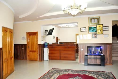 a living room with a fireplace and a tv at Шинам Мехмонхонаси in Eshonguzar