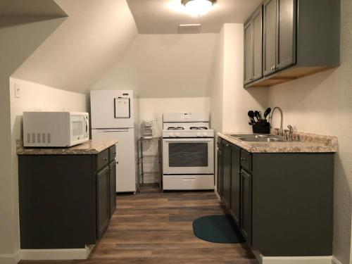 kuchnia z czarnymi szafkami i białymi urządzeniami w obiekcie Unwind in a Bright Comfortable Apartment for 3 w mieście Pittsburgh